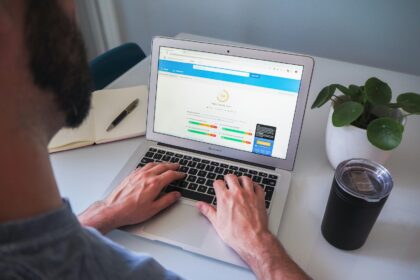 person using macbook pro on white table