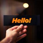 a person holding up a sign that says hello